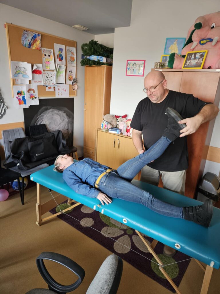 Kobieta na leżance poddawana zabiegom przez rehabilitanta.