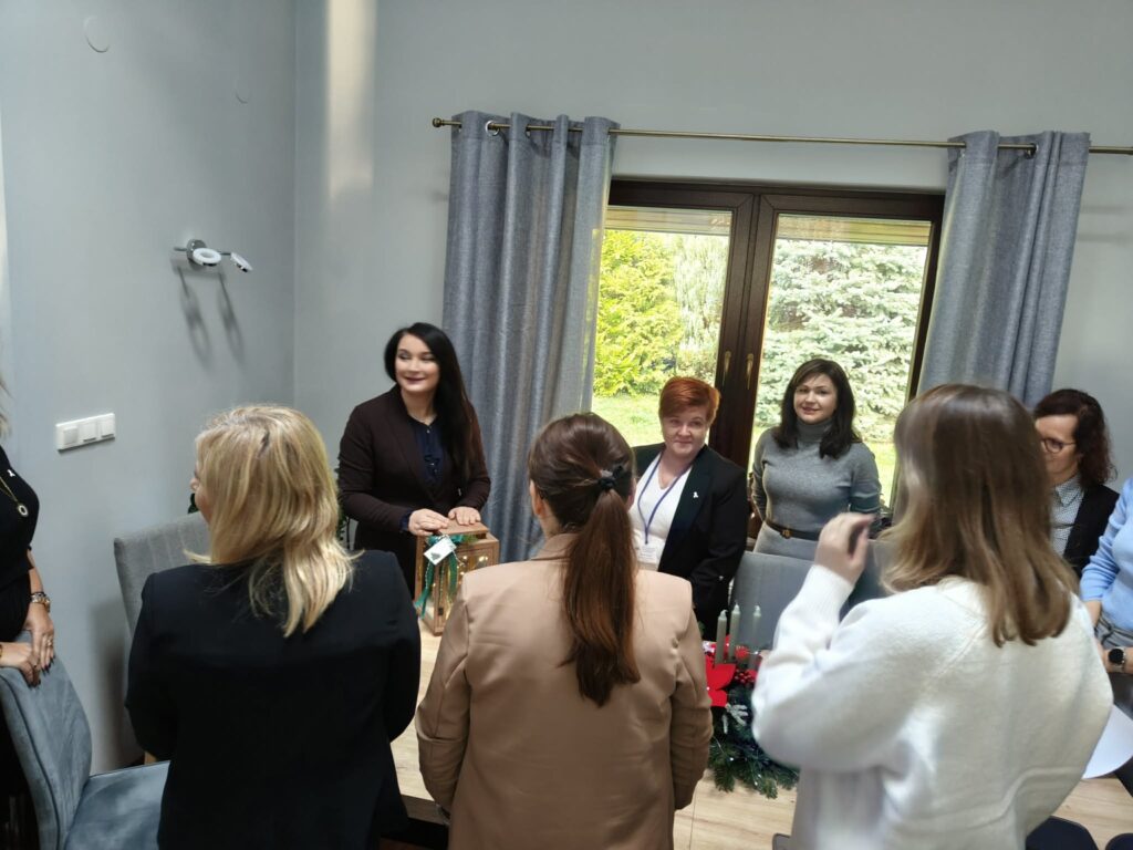 Stojące osoby przy stole.